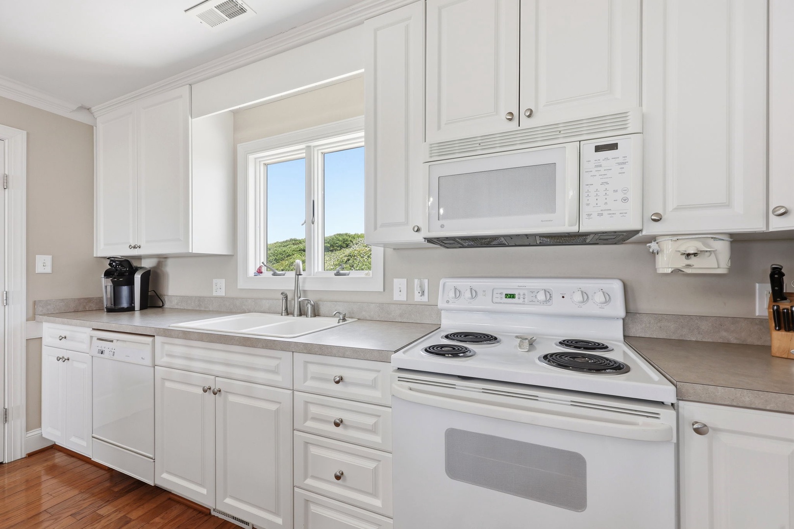 Bright, fully-equipped kitchen with everything you need to whip up your favorite meals, complete with coffee maker and natural light streaming through the window.