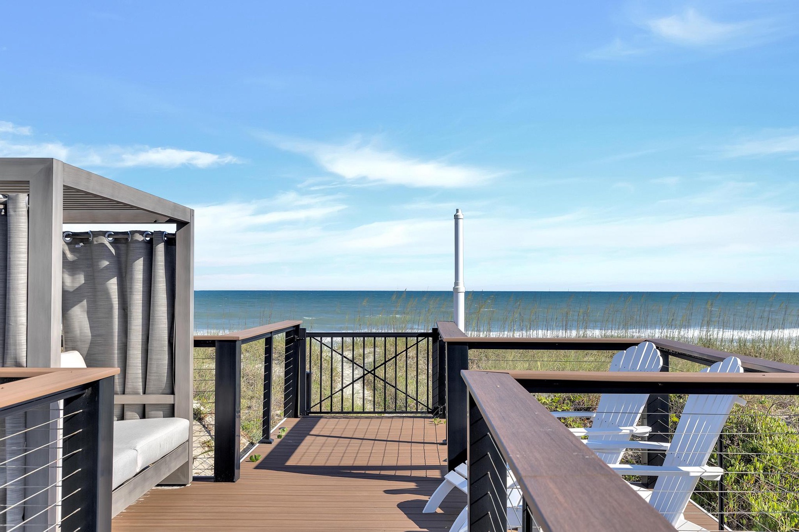 Step onto your private deck and breathe in the coastal air. Comfortable seating awaits as you gaze across natural dunes to the serene sea beyond.