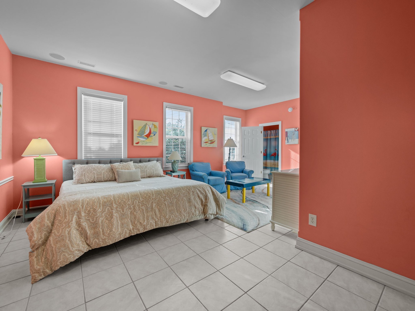 Wake up in your vibrant coral-themed bedroom with comfortable bedding and cozy seating area perfect for relaxing.