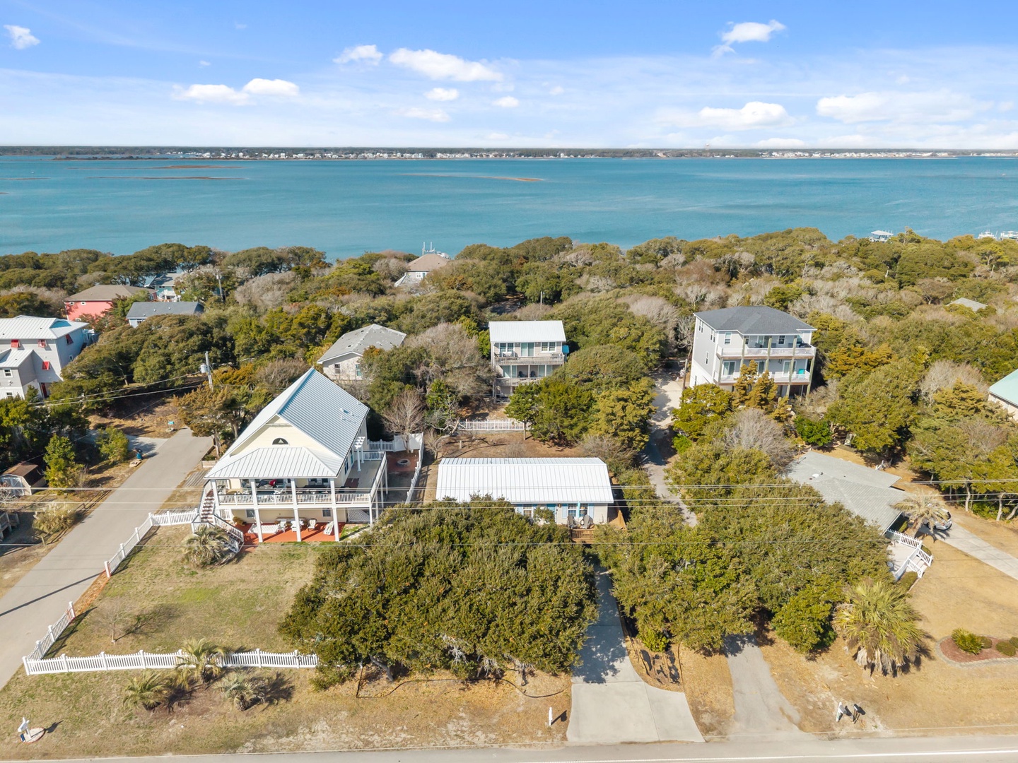 Coastal properties nestled among mature trees offer proximity to pristine turquoise waters and peaceful residential surroundings.