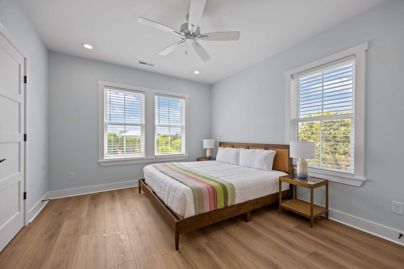 Drift off in your serene bedroom with crisp linens, warm wood floors, and natural light streaming through bright windows.