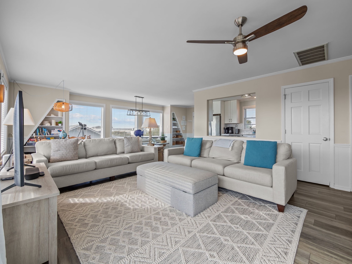 Settle into plush sectional seating with turquoise accents as gentle ceiling fans circulate cool air through your bright, open living space.