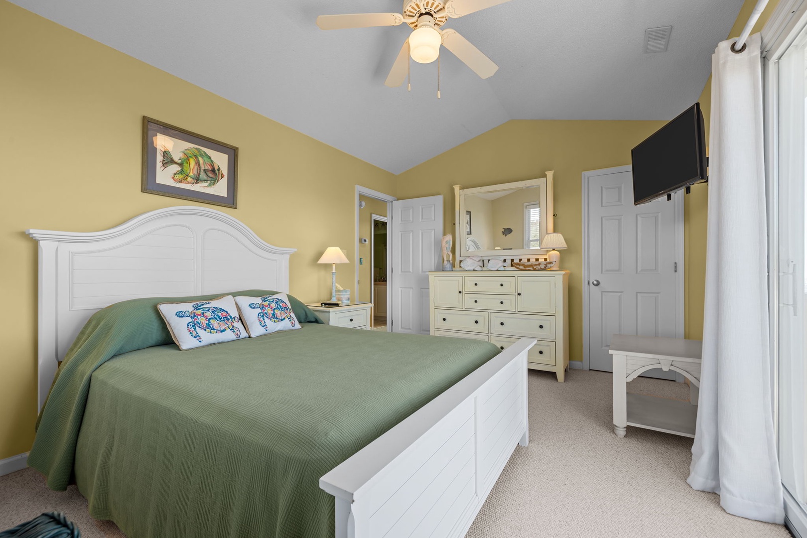 Rest peacefully in your cozy bedroom with cheerful yellow walls, crisp white furnishings, and coastal touches that invite sweet dreams.
