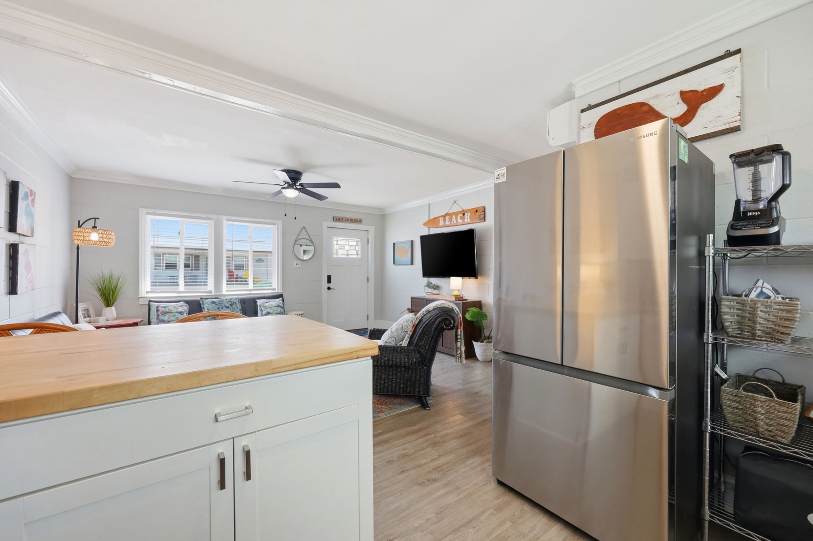 Step into your bright, open living space where coastal charm meets modern comfort. Relax on the cozy sofa, whip up meals at the sleek kitchen island, and enjoy easy access to everything you need for a perfect beach getaway.