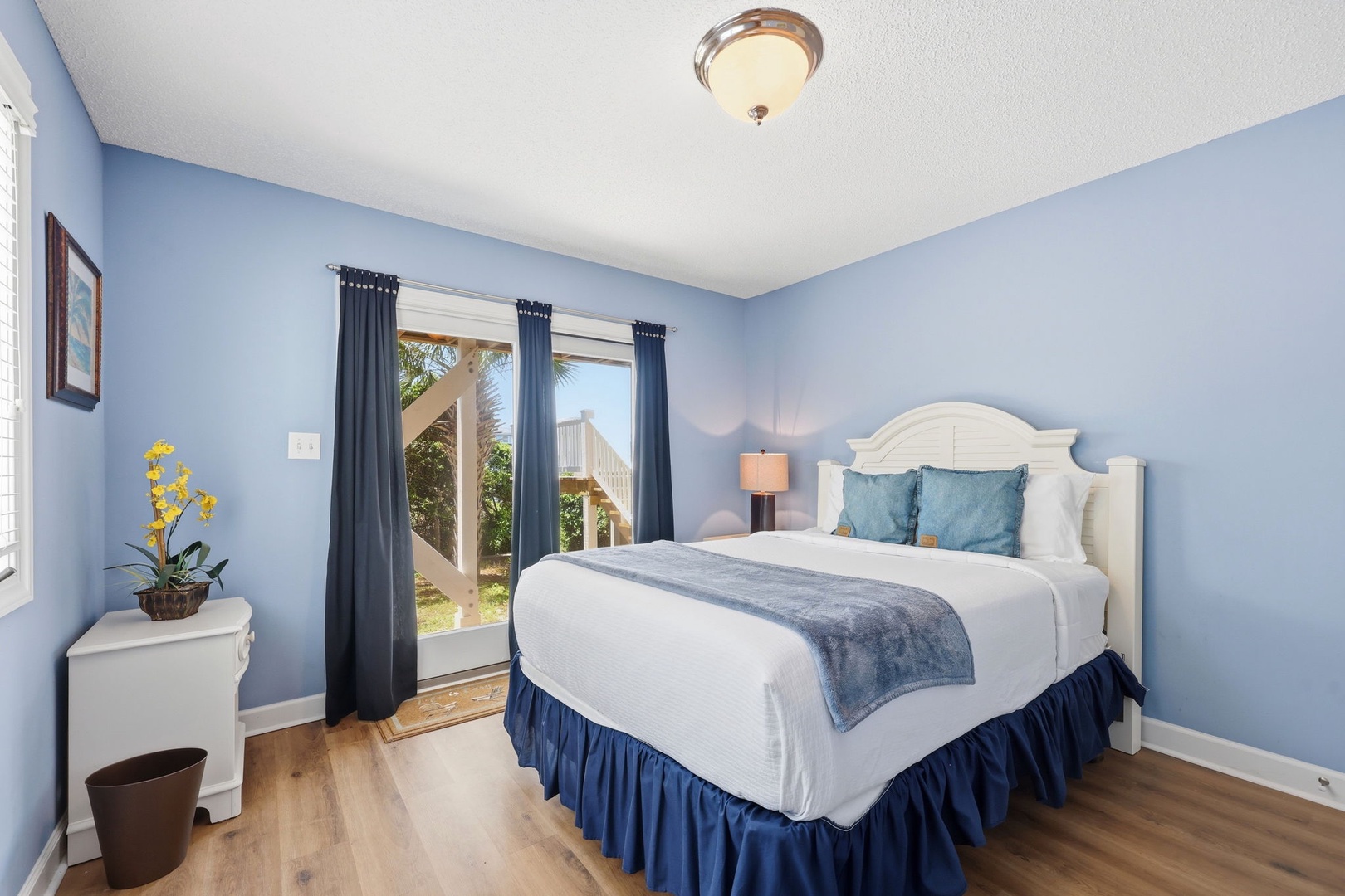 Relax in your serene bedroom, where calming blue tones and crisp linens invite restful nights, while sliding doors open to tropical breezes and sunlit moments.