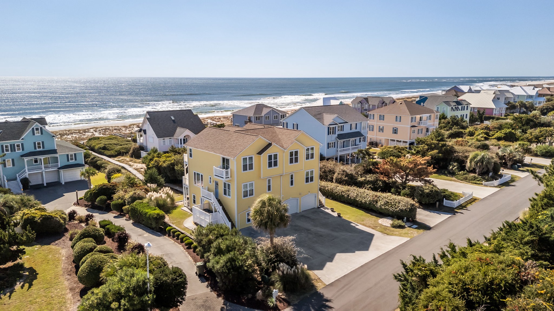 Beachfront community featuring colorful coastal homes with ocean access and pristine sandy shores just steps away.