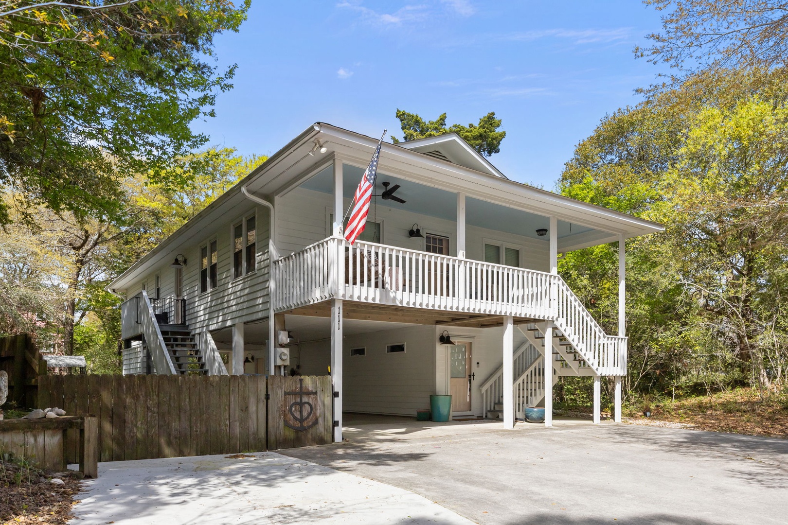 Charming coastal cottage with welcoming covered porch and convenient ground-level parking in a peaceful, tree-lined neighborhood.