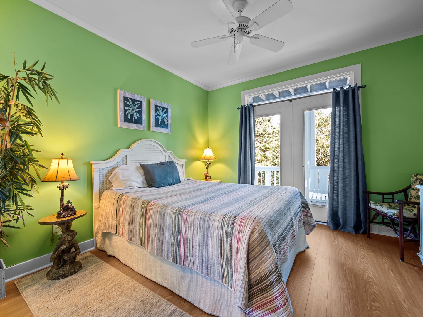 Drift off in this tropical bedroom with vibrant green walls, comfy bed, and private balcony access for morning coffee moments.