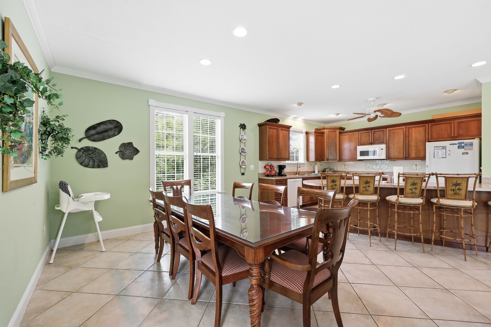 Gather around the dining table for memorable meals, then head to the breakfast bar for casual conversation. Warm wood tones and soft green walls create an inviting space where your group can connect.
