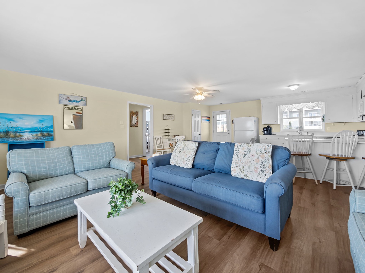 Sink into plush sofas in your bright, open living space where coastal blues meet warm comfort—perfect for relaxing after beach days.