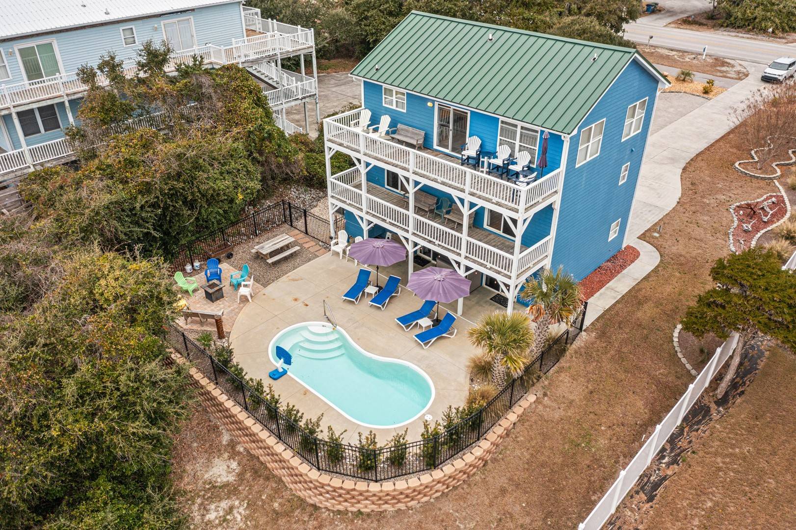 Charming blue beach house with private pool, multi-level decks, and coastal surroundings for the perfect seaside getaway.