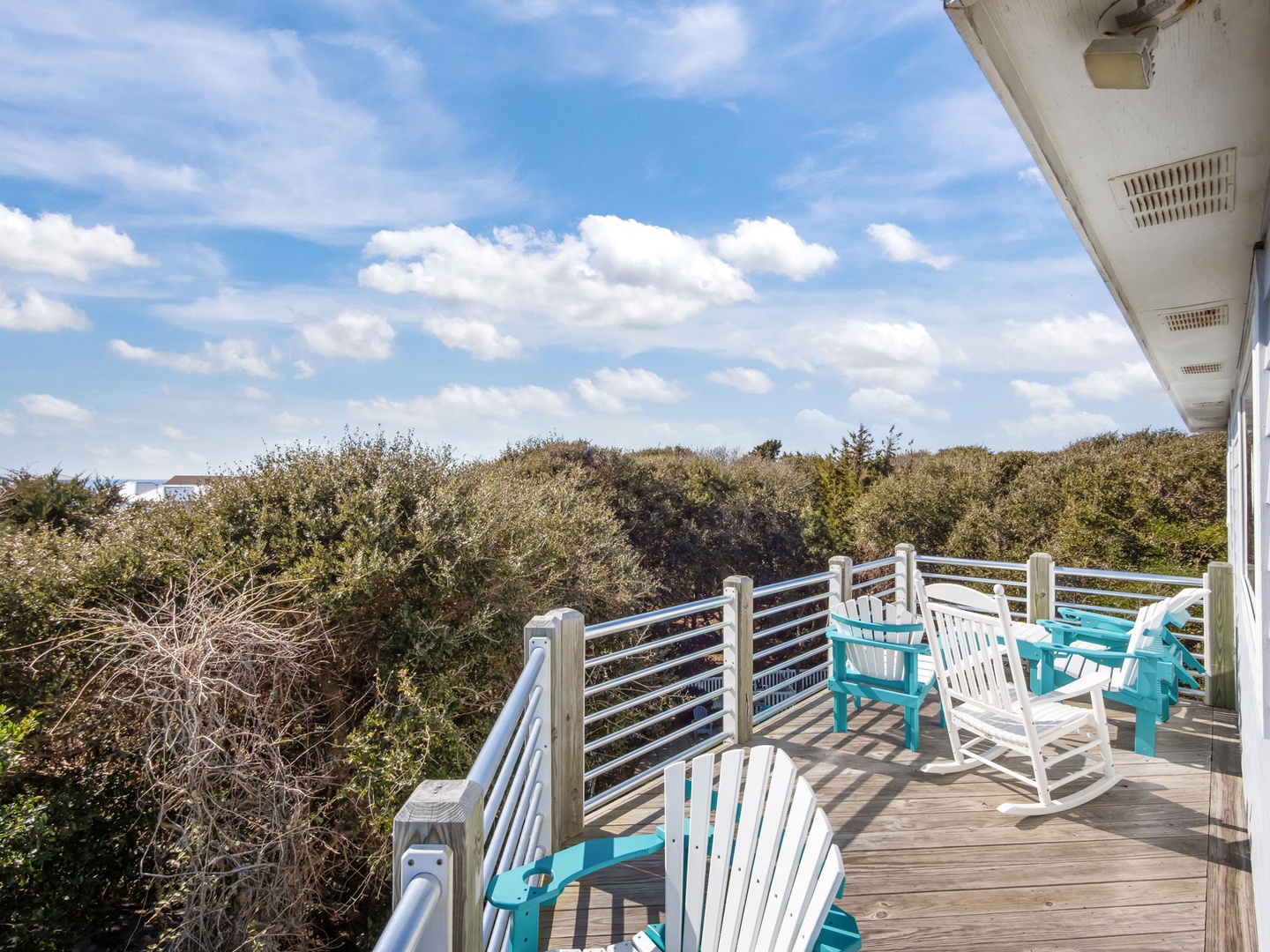 Spacious deck overlooking natural coastal vegetation with comfortable seating for outdoor relaxation.