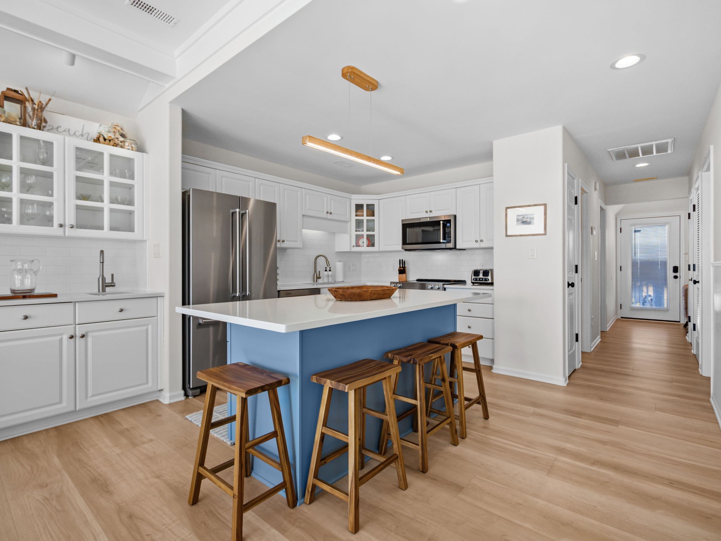 You'll love preparing meals in this bright, fully equipped kitchen with its spacious island and charming blue accents.