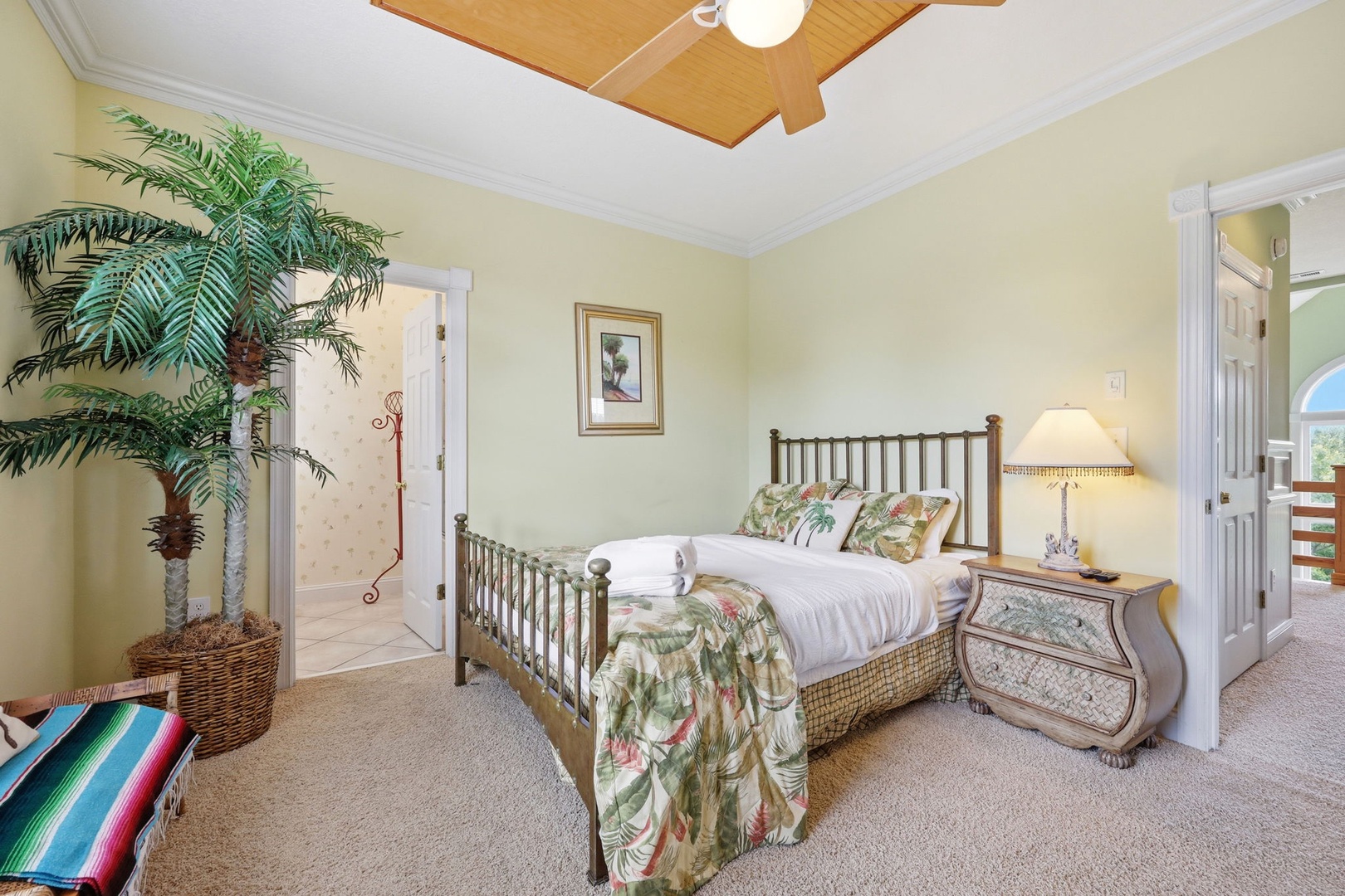 Unwind in your tropical-inspired bedroom with plush linens, elegant furnishings, and a statement tray ceiling—your peaceful retreat after a day of adventure.