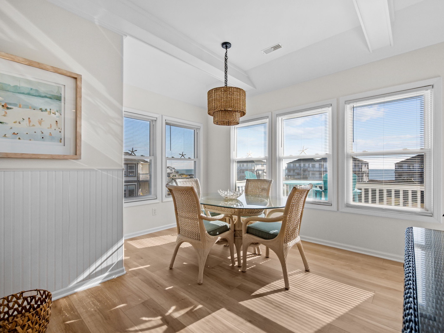 Share morning meals in your sunny dining nook, where natural wicker furnishings and ocean glimpses create a serene coastal breakfast spot.