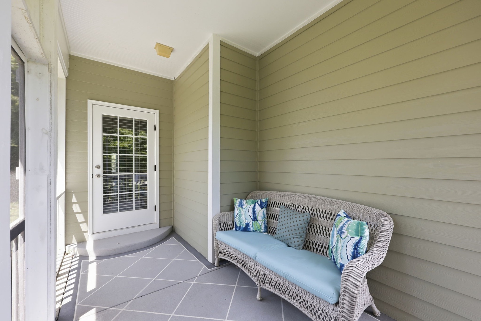 Step onto your private porch and sink into the cozy wicker sofa—a perfect spot to enjoy morning coffee or unwind after exploring the area.