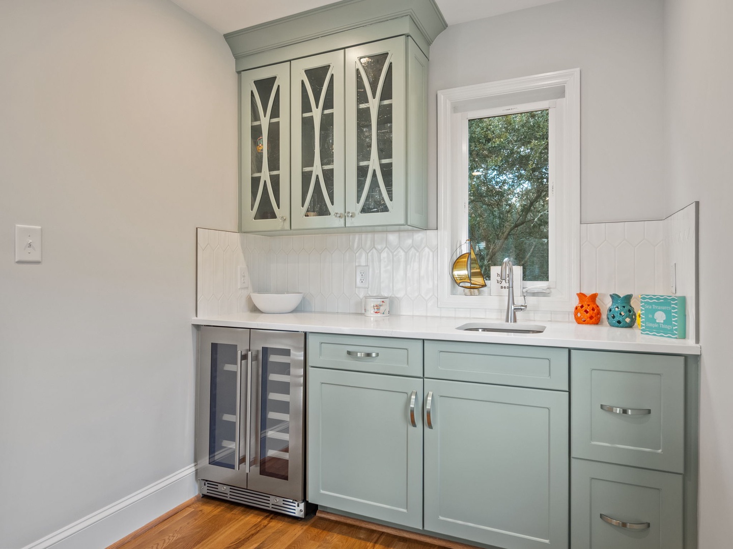 Your charming wet bar features elegant sage-green cabinets and marble countertops, perfect for morning coffee or evening wine.