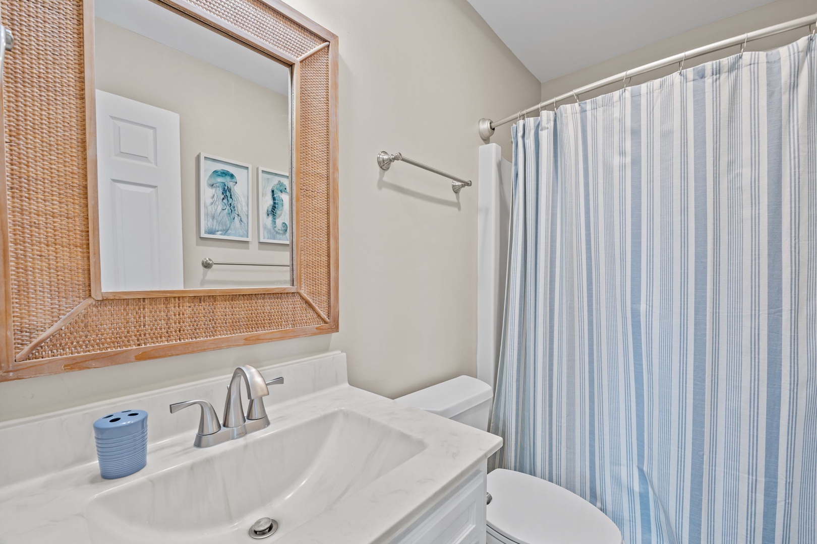 Step into your private bathroom featuring coastal-inspired décor with natural textures and soothing blue accents for a refreshing start to your day.