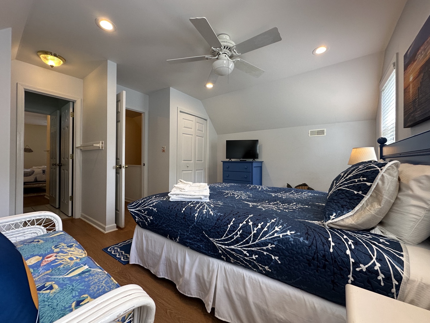 Relax in your serene bedroom with calming navy and white linens, a ceiling fan to keep you cool, and your own TV for unwinding after a day of exploring.