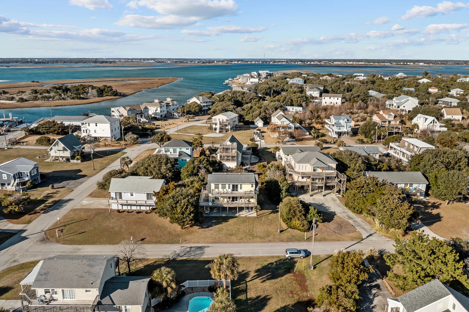 Aerial view of a coastal residential community with waterfront access and nearby beach areas.