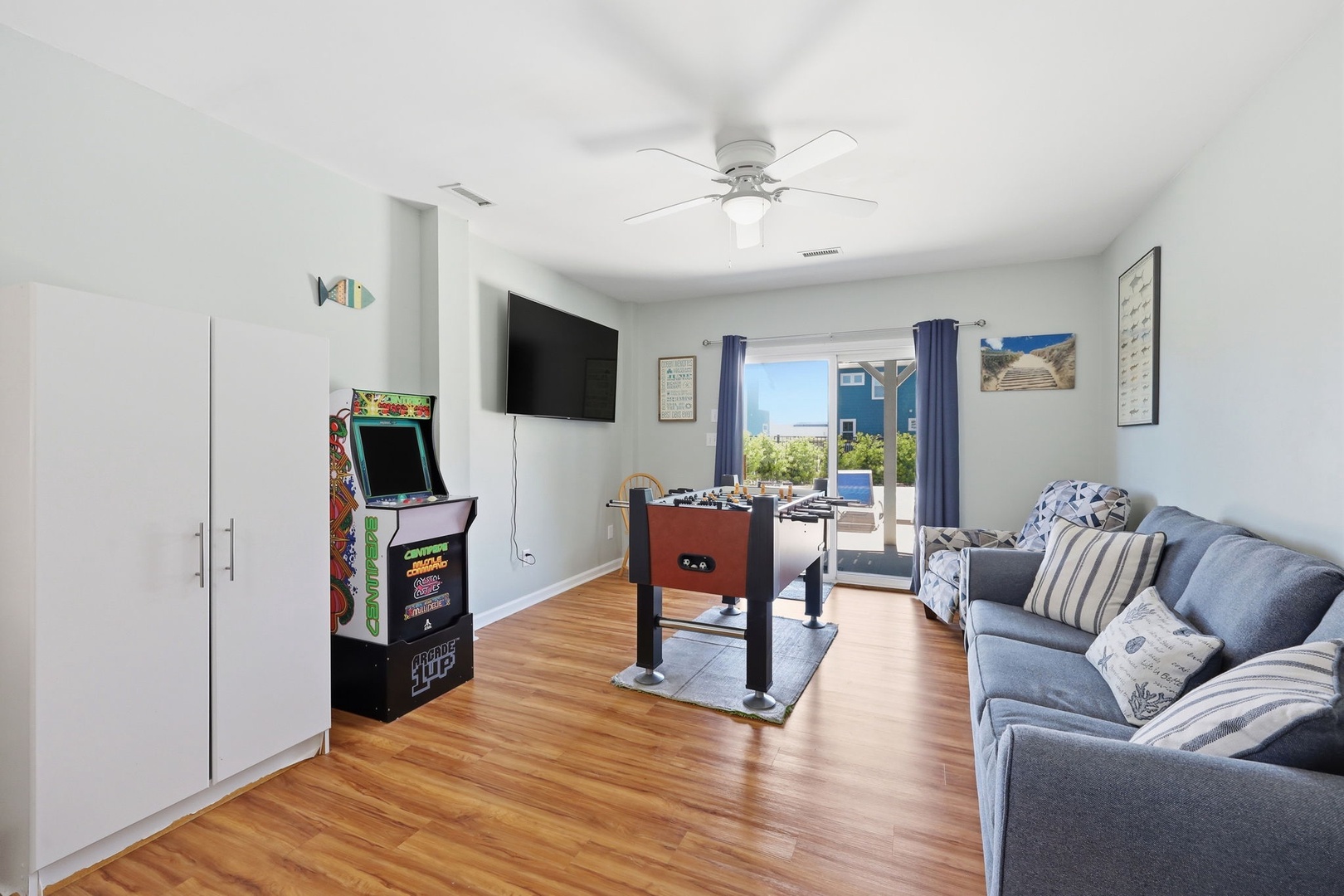 Your bright, coastal living room invites you to unwind with arcade games, foosball fun, and relaxing ocean views just beyond the door—perfect for laid-back vacation days.