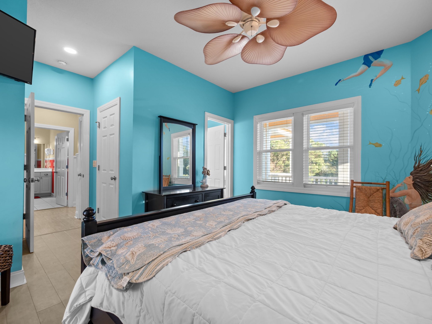 Drift to sleep in your ocean-themed bedroom with turquoise walls and tropical ceiling fan creating gentle breezes.