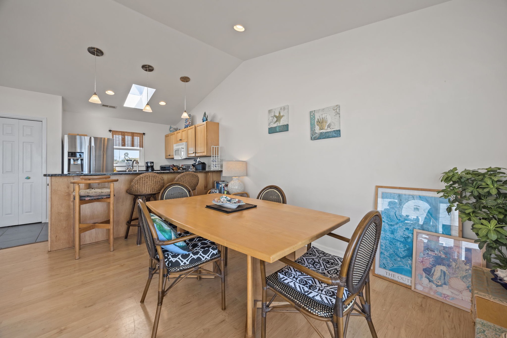 Gather around your spacious dining table for morning coffee or evening meals in this bright, open-concept space with modern kitchen and vaulted ceilings.