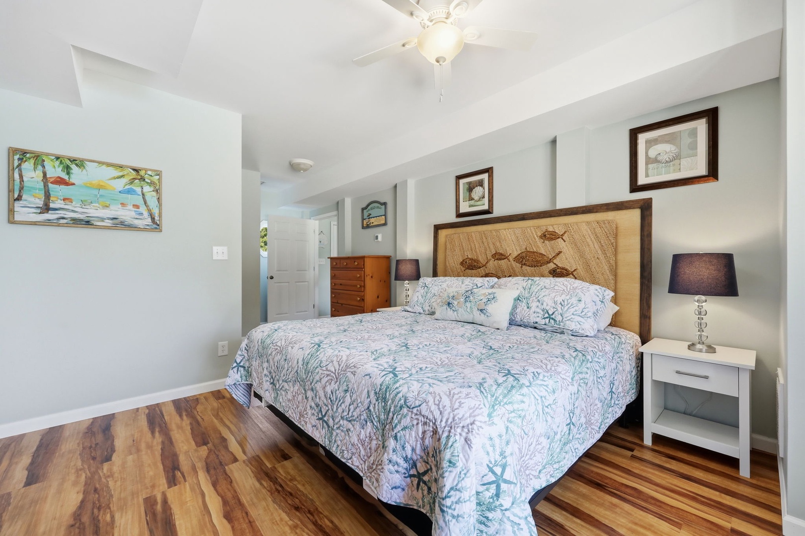 Sink into plush coastal bedding and let warm wood tones wrap you in comfort. Your beachside retreat awaits with charming nautical touches and restful vibes.