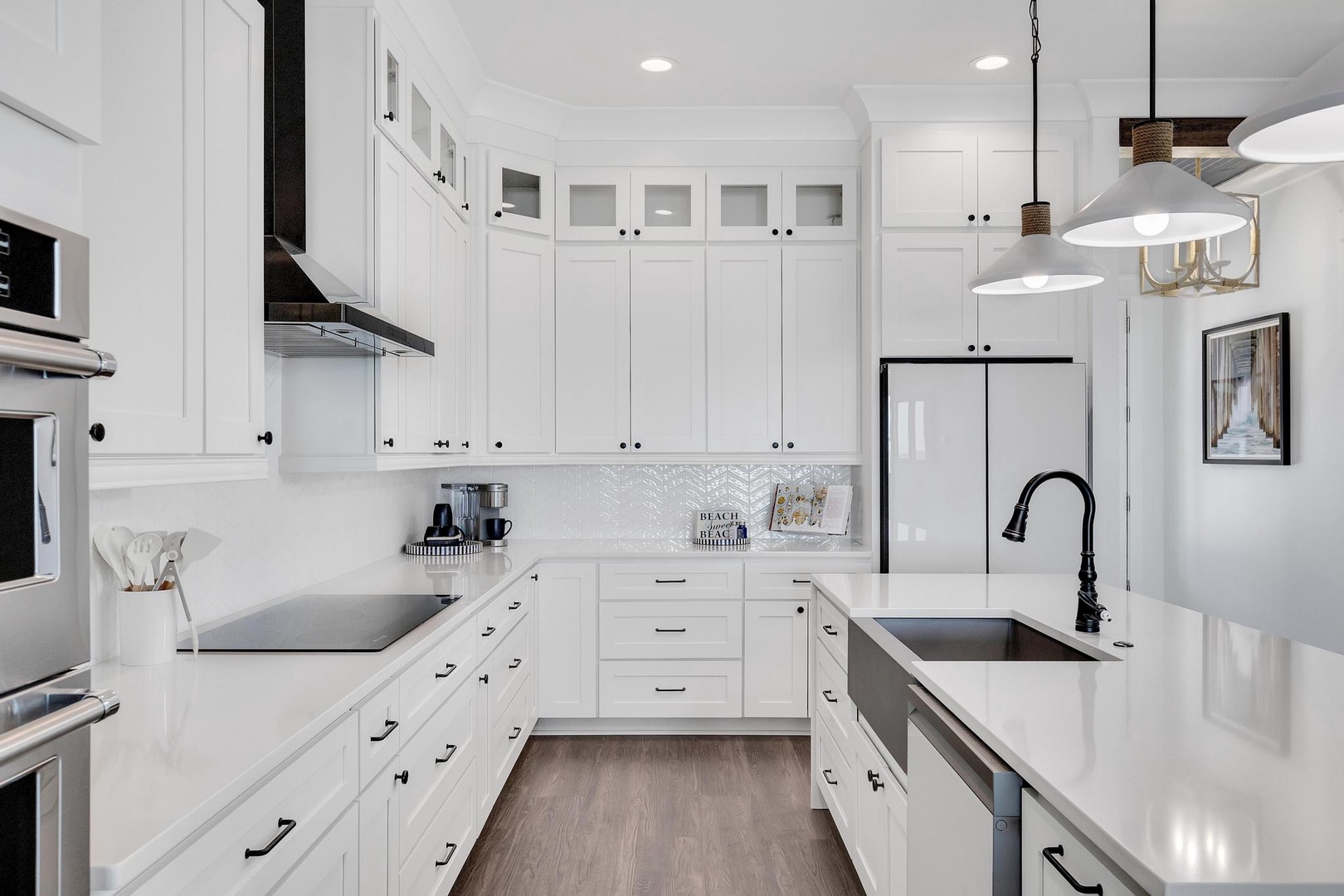 Step into your fully-equipped gourmet kitchen, where bright white cabinetry, sleek countertops, and modern appliances invite you to create delicious meals in a space that feels both elegant and welcoming.