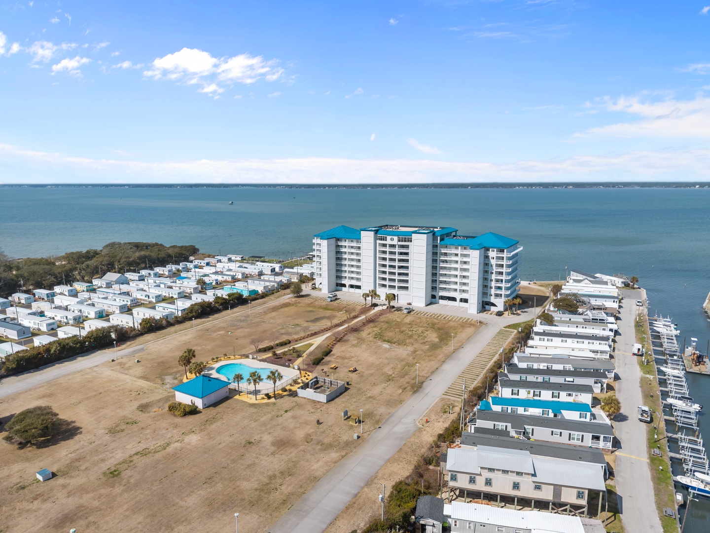 Stunning aerial view of waterfront property nestled between pristine coastline and peaceful marina surroundings.