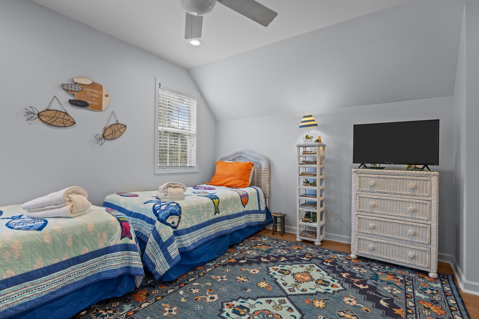 Your coastal-themed bedroom offers twin beds with ocean-inspired linens, peaceful gray walls, and charming nautical decor to drift off to sleep.