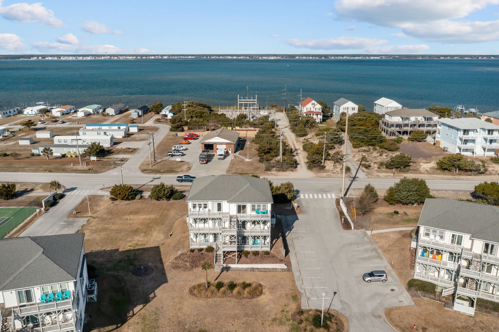 Coastal community with vacation homes nestled between sound waters and oceanfront, offering peaceful retreat near pristine beaches.