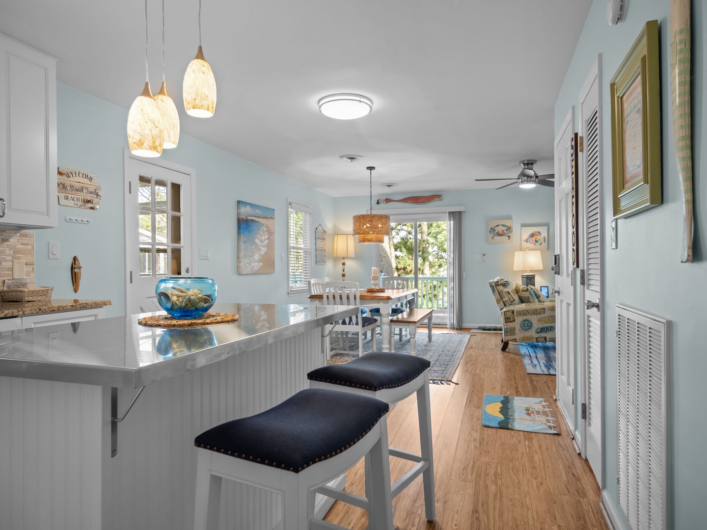 Your coastal-inspired open-concept space flows from kitchen to dining to living, perfect for gathering with beach-themed charm and modern comfort.