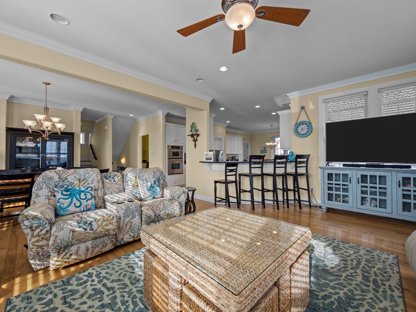Your coastal-themed living space flows seamlessly into the kitchen, with comfortable seating and entertainment center perfect for family time.