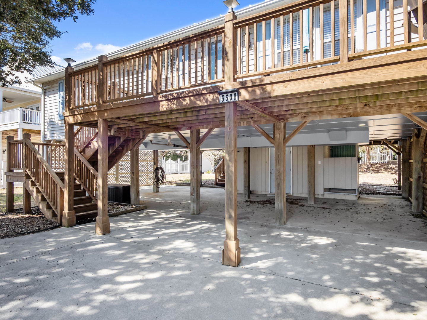 Elevated beach house structure with covered parking and outdoor storage space beneath the main living area.