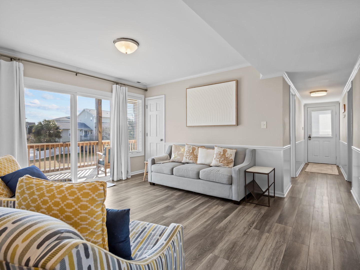 Unwind in this bright living room where coastal comfort meets modern style, with sunshine streaming through your private balcony doors.