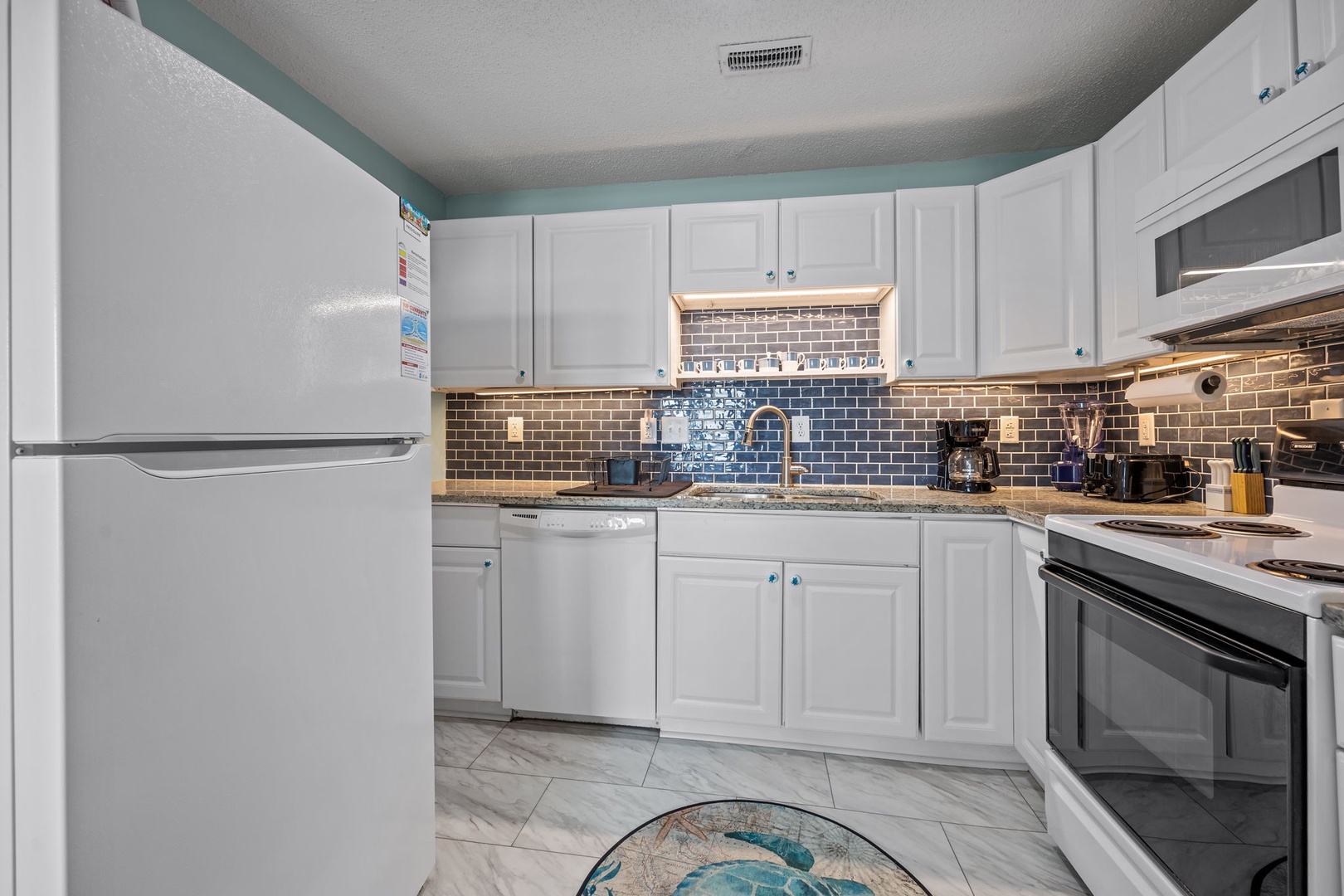 Your bright, fully equipped kitchen awaits with modern appliances and beautiful tile details.