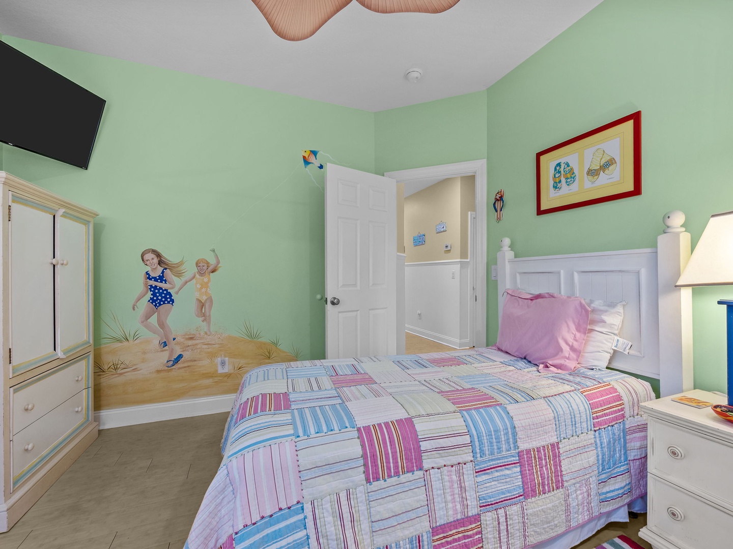 Your little ones will love this cheerful bedroom with playful beach murals, cozy bedding, and fun decor that makes bedtime an adventure.