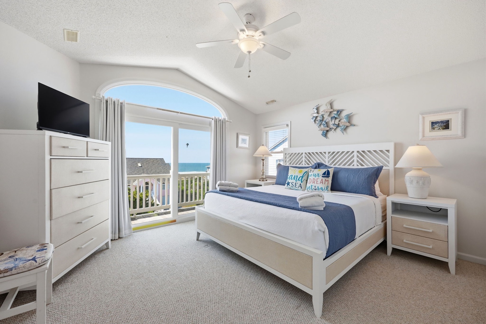 Wake up to stunning ocean views from your coastal retreat. This inviting bedroom features a plush bed with coastal accents, beach-inspired decor, and a private balcony overlooking the sea breeze.