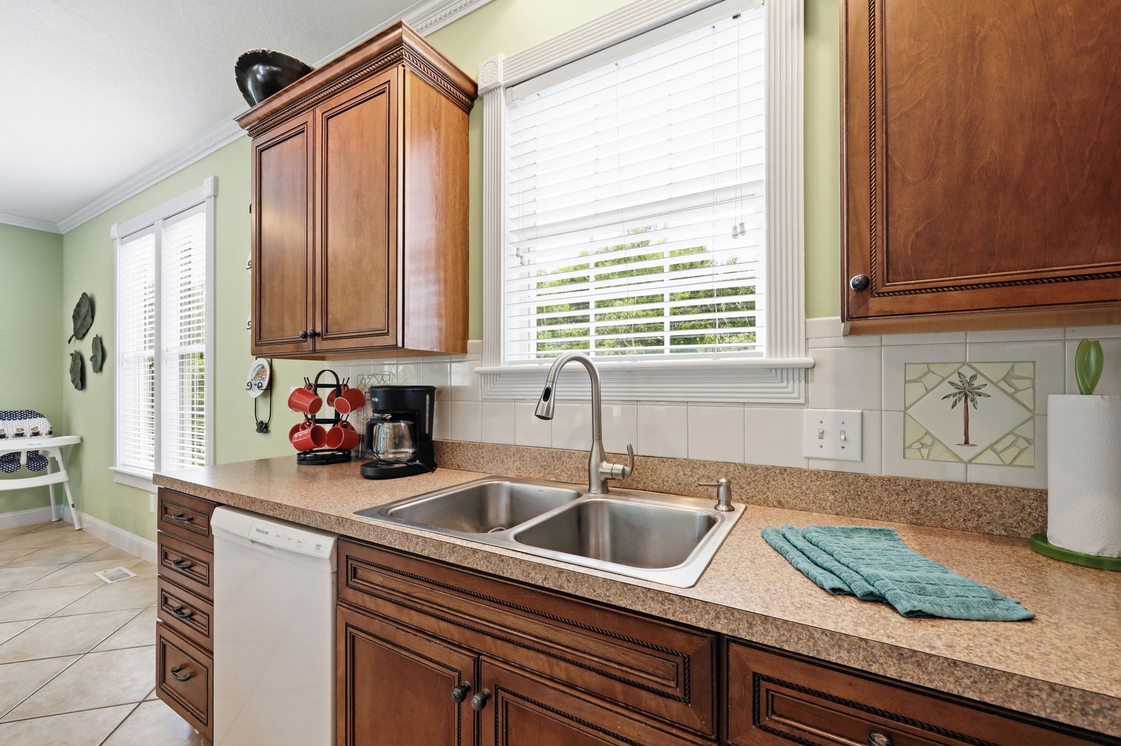 Your kitchen welcomes you with warm wood cabinetry, speckled granite counters, and a double sink. Enjoy tropical touches and plenty of natural light for cooking, with all the appliances you need.
