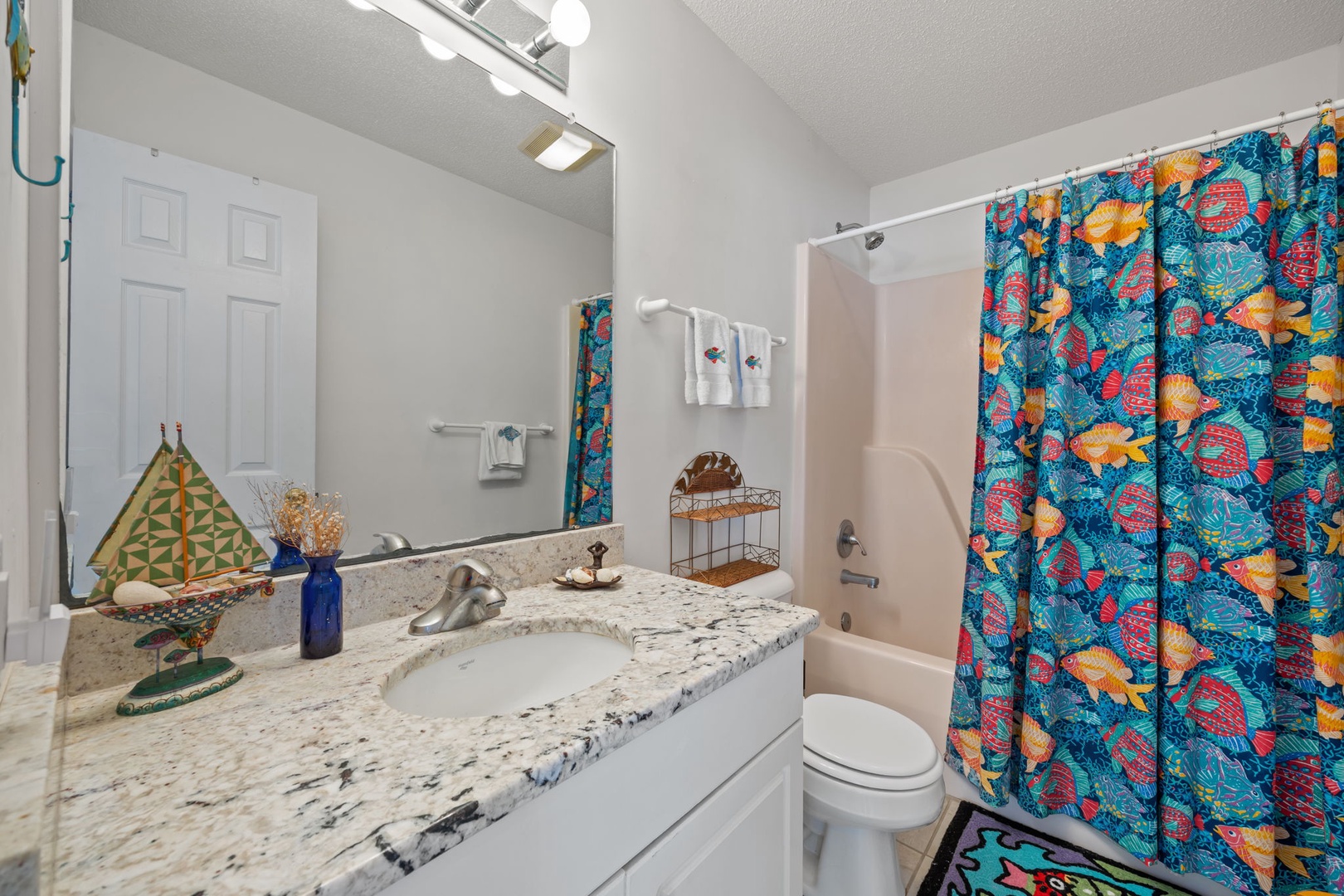 Your vibrant bathroom features granite countertops and tropical-themed touches that make your daily routine feel like a colorful escape.