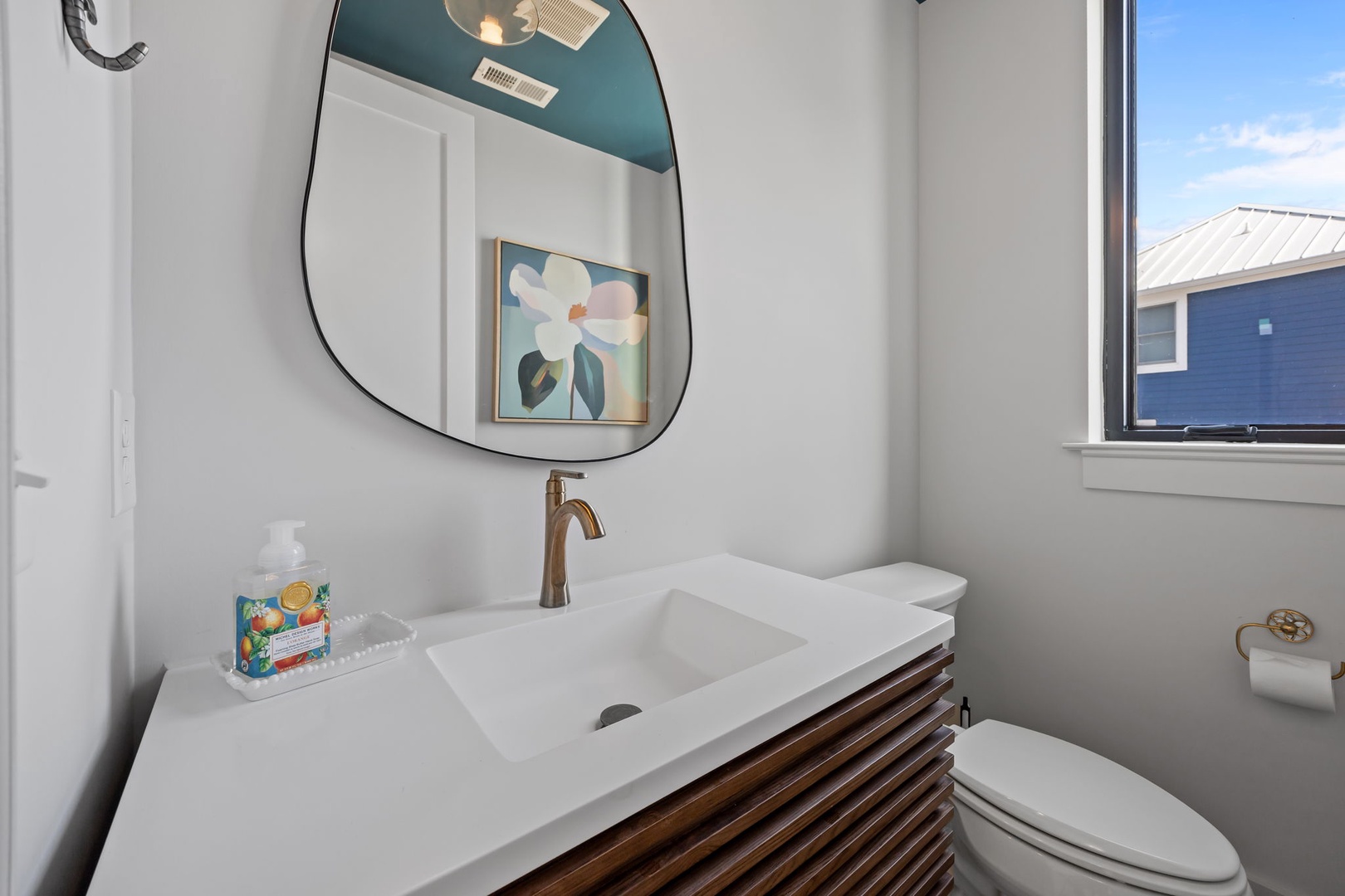 Refresh in your stylishly appointed bathroom with modern fixtures, artistic touches, and natural light streaming through the window.
