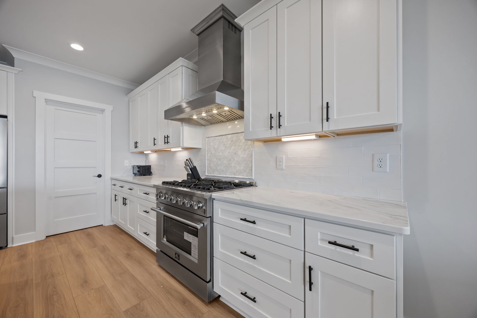Your culinary dreams come true in this pristine white kitchen with premium stainless appliances and gleaming countertops.