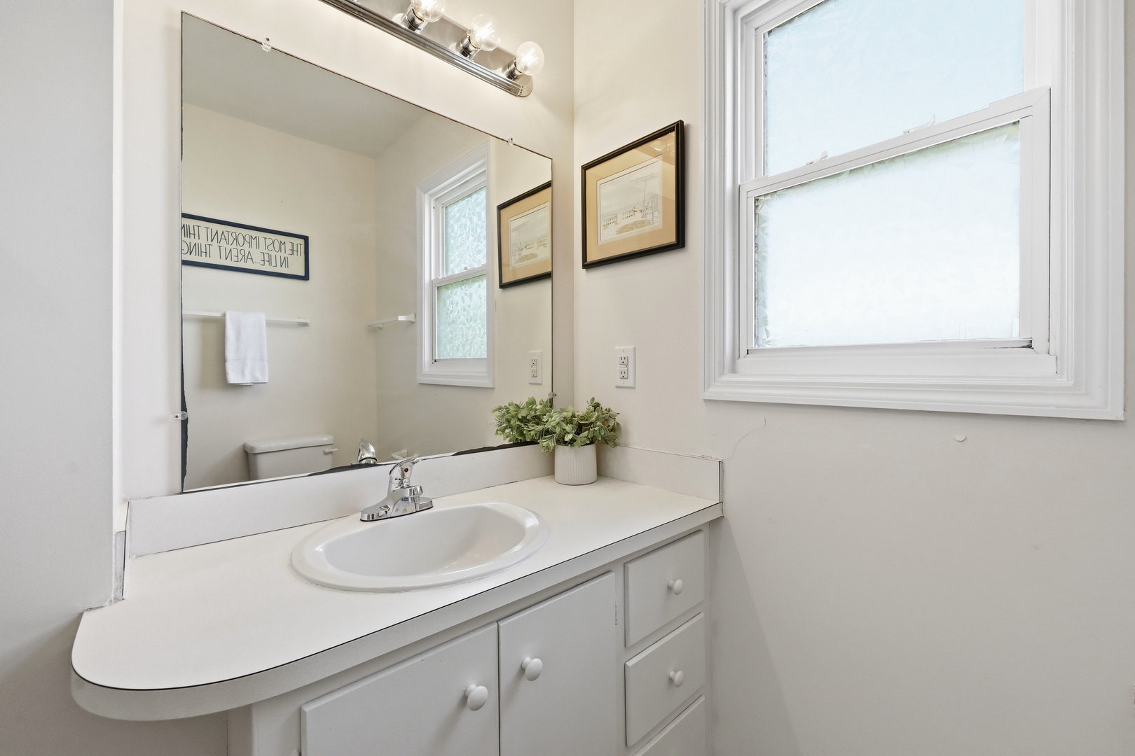 Step into your private bathroom, where soft natural light, a spacious vanity, and fresh, calming touches create a peaceful retreat for your morning routine.