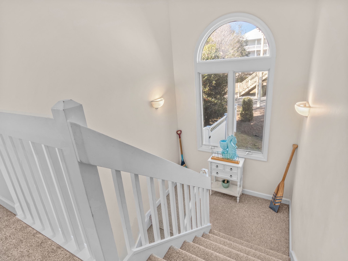 Bright staircase landing with charming arched window offering natural light and peaceful views of your surroundings.