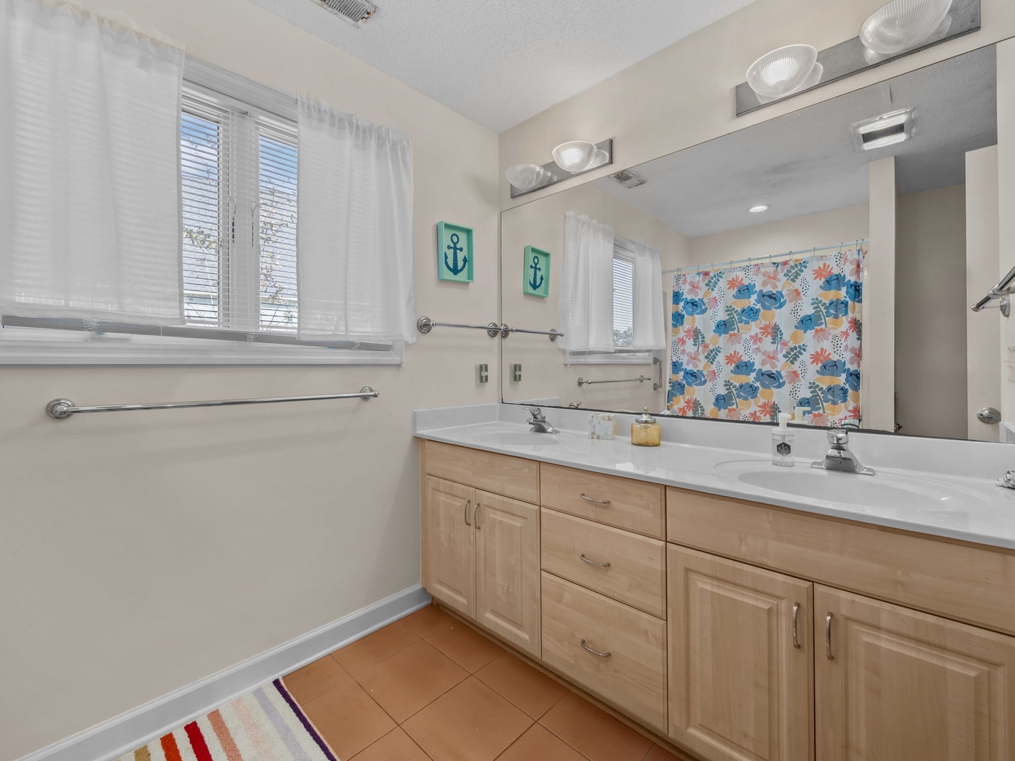 Start your day in this bright bathroom with dual sinks and nautical touches - perfect for sharing morning routines.