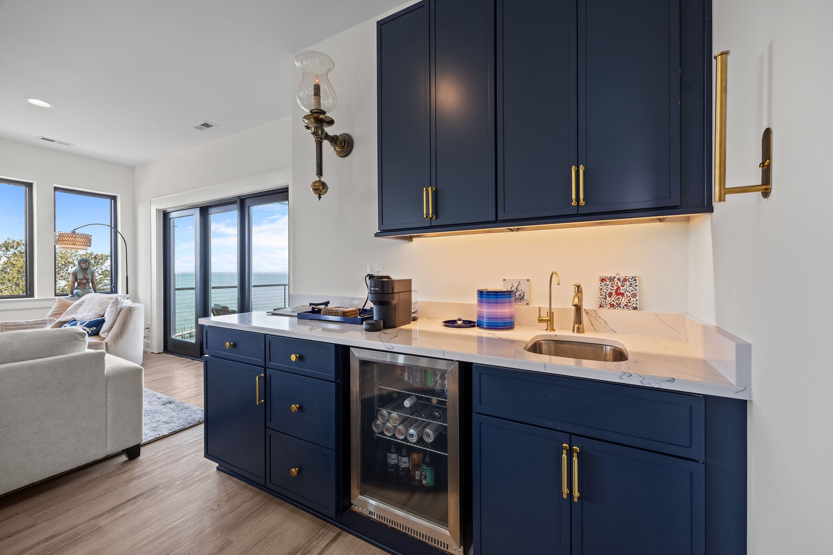 Your stylish kitchenette features elegant navy cabinetry, gleaming countertops, and stunning water views that create the perfect backdrop for memorable vacation meals.