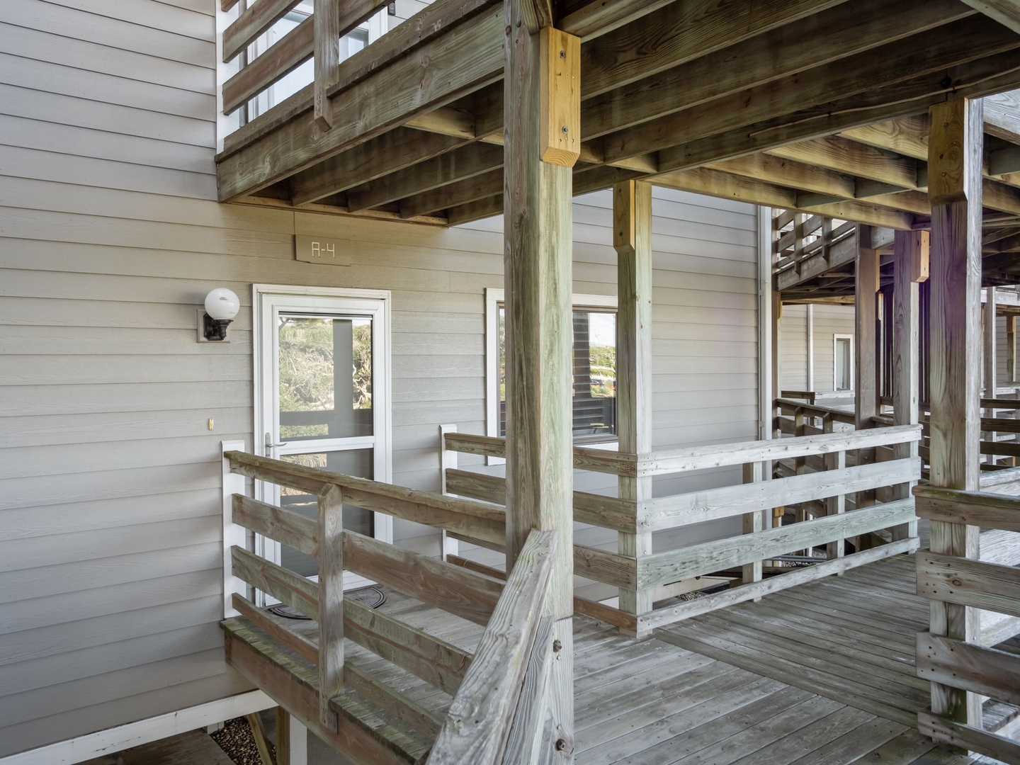 Multi-level wooden deck structure featuring rustic charm with natural wood beams and railings surrounding the property entrance.