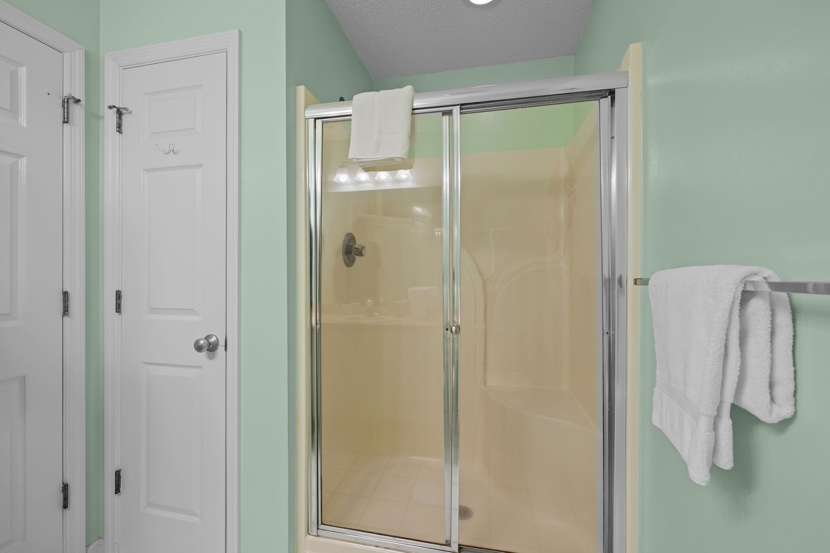 Step into your private bathroom retreat with a spacious glass shower and fresh towels waiting for your arrival.