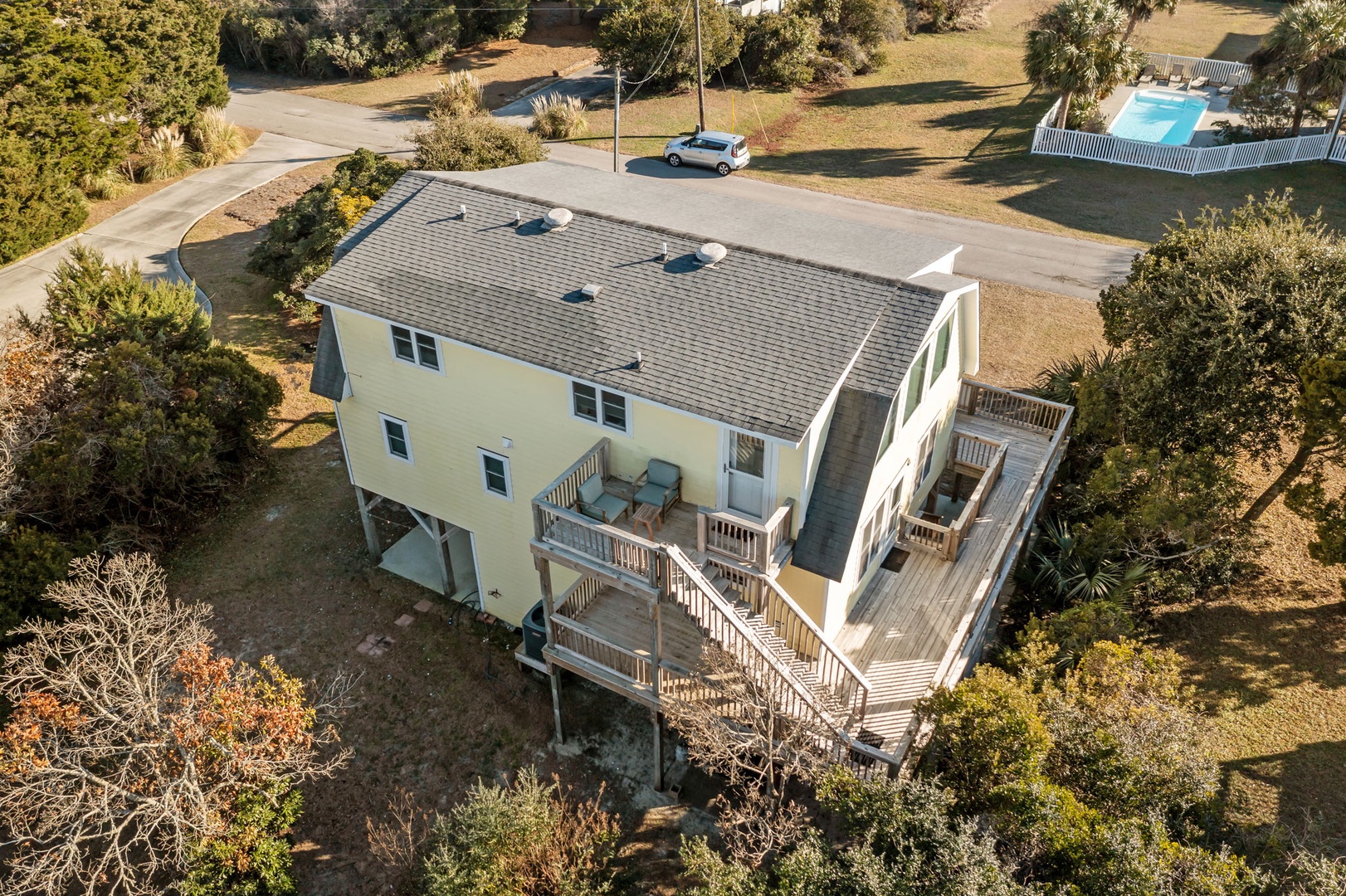 Elevated beachside home featuring expansive wraparound decks and multi-level design in a peaceful coastal community setting.